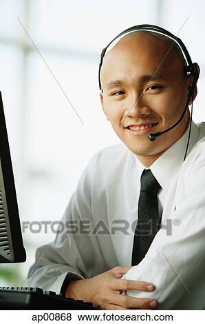 Stock Photo - Man with headset, smiling, looking at camera. Fotosearch