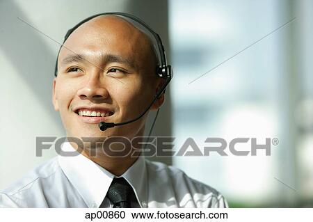 Man with headset, smiling, looking away View Large Photo Image Stock Image - Man with headset, smiling, looking away. Fotosearch