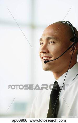 Man with headset, smiling, looking away View Large Photo Image Stock Photograph - Man with headset, smiling, looking away. Fotosearch