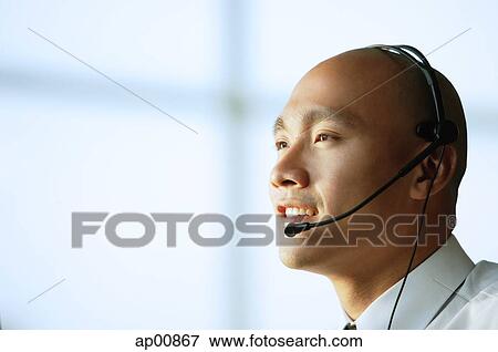 Man with headset, smiling, side view View Large Photo Image Stock Photo - Man with headset, smiling, side view. Fotosearch