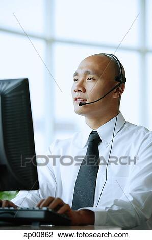 Man with headset, using computer View Large Photo Image Stock Image - Man with headset, using computer. Fotosearch