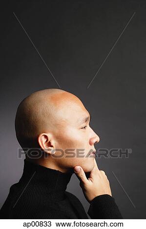Man with shaved head, hand on chin, looking away View Large Photo Image Stock Image - Man with shaved head, hand on chin, looking away. Fotosearch