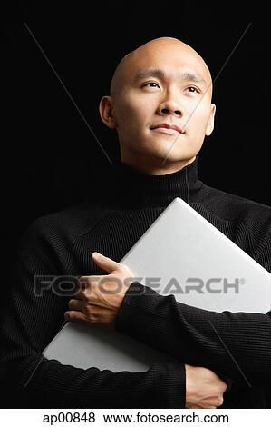 Man with shaved head, hugging laptop, looking away View Large Photo Image Stock Photo - Man with shaved head, hugging laptop, looking away. Fotosearch