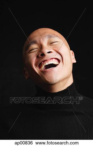 Stock Photograph - Man with shaved head, laughing, portrait. Fotosearch