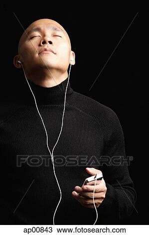 Man with shaved head, listening to music with earphones, eyes closed View Large Photo Image Stock Image - Man with shaved head, listening to music with earphones, eyes closed. Fotosearch