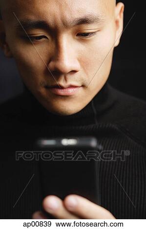 Man with shaved head, looking at mobile phone, selective focus View Large Photo Image Stock Photo - Man with shaved head, looking at mobile phone, selective focus. Fotosearch