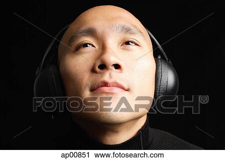 Man with shaved head, wearing headphones View Large Photo Image Stock Image - Man with shaved head, wearing headphones. Fotosearch