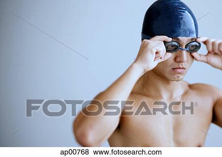 Man with swimming cap, adjusting goggles View Large Photo Image Stock Photo - Man with swimming cap, adjusting goggles. Fotosearch