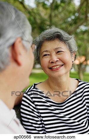 Mature couple facing each other smiling, woman wearing striped shirt View Large Photo Image Stock Photograph - Mature couple facing each other smiling, woman wearing striped shirt. Fotosearch