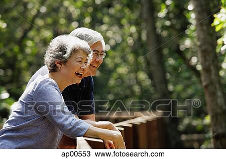 Mature couple leaning on railing, laughing, looking away View Large Photo Image Stock Image - Mature couple leaning on railing, laughing, looking away. Fotosearch
