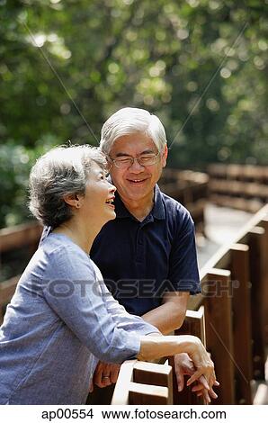 Mature couple side by side, smiling, woman looking up View Large Photo Image Picture - Mature couple side by side, smiling, woman looking up. Fotosearch