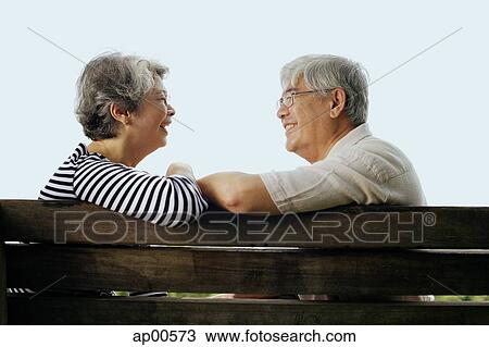 Stock Image - Mature couple sitting face to face, portrait. Fotosearch
