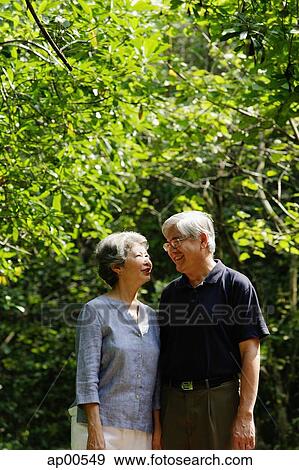 Mature couple, standing side by side, smiling View Large Photo Image Stock Photo - Mature couple, standing side by side, smiling. Fotosearch