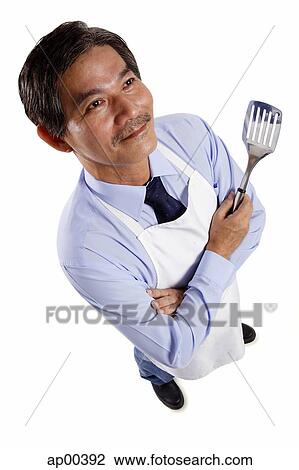 Mature man wearing apron, holding spatula View Large Photo Image Stock Image - Mature man wearing apron, holding spatula. Fotosearch
