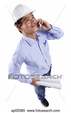 Mature man wearing construction hat, using mobile phone, carrying blueprints View Large Photo Image Stock Photography - Mature man wearing construction hat, using mobile phone, carrying blueprints. Fotosearch