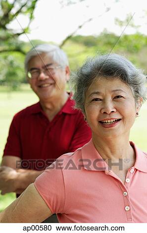 Mature woman, looking at camera, man standing behind her View Large Photo Image Stock Image - Mature woman, looking at camera, man standing behind her. Fotosearch
