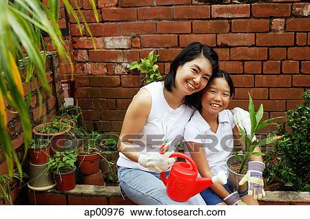 Mother and daughter, sitting in garden, looking at camera View Large Photo Image Stock Photograph - Mother and daughter, sitting in garden, looking at camera. Fotosearch