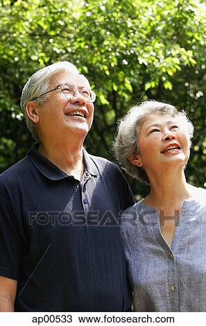 Stock Image - Senior couple looking up, smiling. Fotosearch
