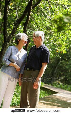 Senior couple standing, facing each other, smiling View Large Photo Image Stock Photography - Senior couple standing, facing each other, smiling. Fotosearch