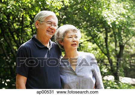 Senior couple standing side by side, looking away, smiling View Large Photo Image Stock Image - Senior couple standing side by side, looking away, smiling. Fotosearch