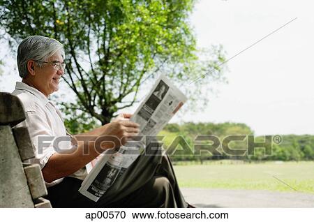 Senior man sitting on bench in park reading newspaper View Large Photo Image Stock Image - Senior man sitting on bench in park reading newspaper. Fotosearch