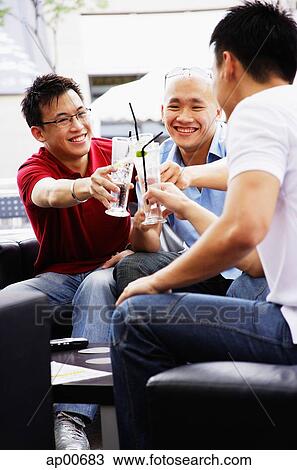 Three guys toasting with drinks View Large Photo Image Stock Image - Three guys toasting with drinks. Fotosearch