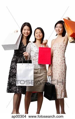 Three young women carrying shopping bags View Large Photo Image Picture - Three young women carrying shopping bags. Fotosearch