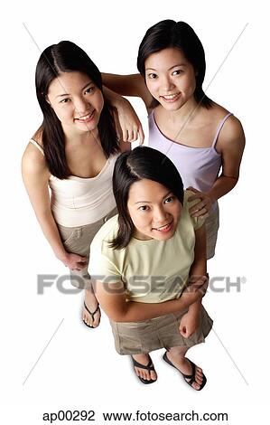 Stock Image - Three young women, looking up at camera. Fotosearch