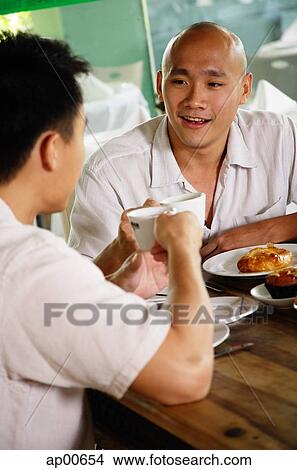 Two men at a cafe, eating View Large Photo Image Picture - Two men at a cafe, eating. Fotosearch