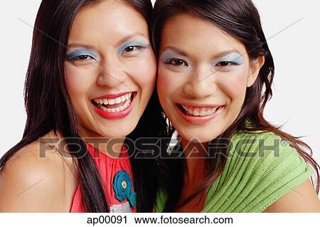 Two women looking at camera, smiling View Large Photo Image Stock Image - Two women looking at camera, smiling. Fotosearch