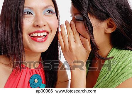 Two women, one looking up, woman next to her whispering View Large Photo Image Stock Photograph - Two women, one looking up, woman next to her whispering. Fotosearch