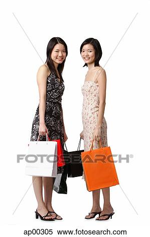 Two young women carrying shopping bags View Large Photo Image Stock Photography - Two young women carrying shopping bags. Fotosearch