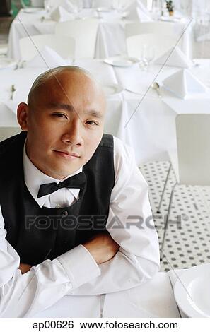 Waiter sitting at table, arms crossed, looking at camera View Large Photo Image Stock Photograph - Waiter sitting at table, arms crossed, looking at camera. Fotosearch