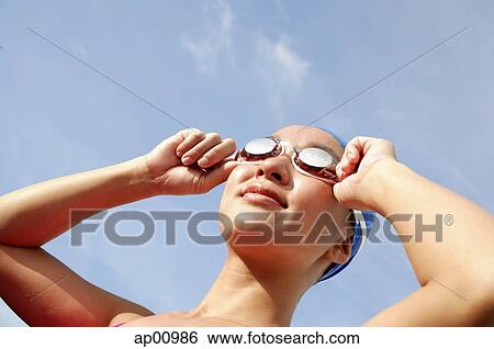 Stock Photograph - Woman adjusting swimming goggles. Fotosearch