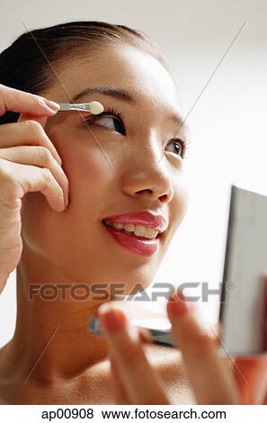 Stock Photo - Woman applying eye shadow. Fotosearch