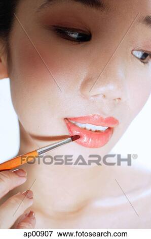 Woman applying lipstick with lip brush View Large Photo Image Stock Photo - Woman applying lipstick with lip brush. Fotosearch