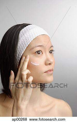 Stock Photo - Woman applying moisturizer. Fotosearch