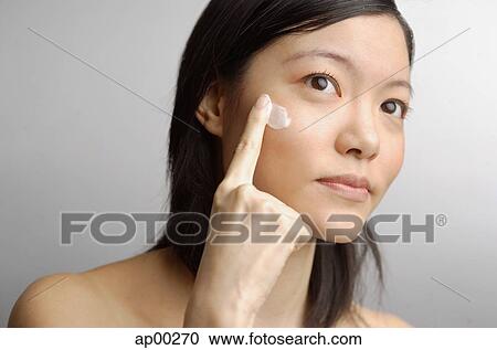 Woman applying moisturizer to face View Large Photo Image Stock Image - Woman applying moisturizer to face. Fotosearch