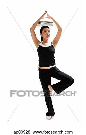 Stock Photo - Woman balancing books on her head, standing on one leg. Fotosearch