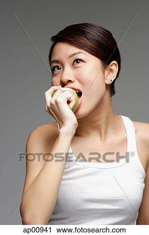 Stock Image - Woman biting into apple. Fotosearch