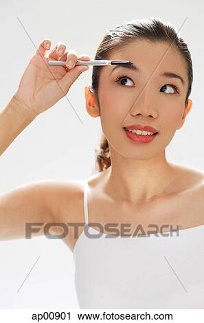 Stock Image - Woman brushing eyebrows. Fotosearch