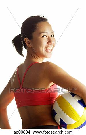 Woman carrying basketball, looking over shoulder at camera View Large Photo Image Picture - Woman carrying basketball, looking over shoulder at camera. Fotosearch