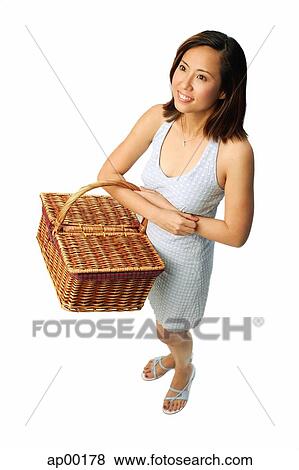 Woman carrying picnic basket, looking away View Large Photo Image Stock Photo - Woman carrying picnic basket, looking away. Fotosearch