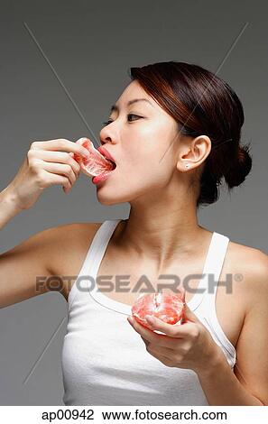 Woman eating an orange View Large Photo Image Stock Image - Woman eating an orange. Fotosearch