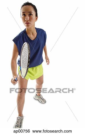 Stock Photograph - Woman holding badminton racket, looking upwards. Fotosearch