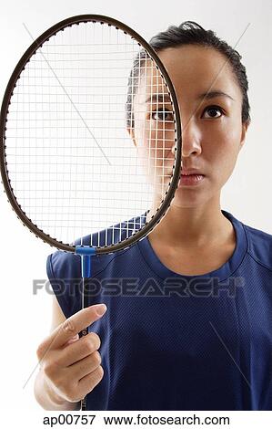Stock Photo - Woman holding badminton racket next to her face. Fotosearch