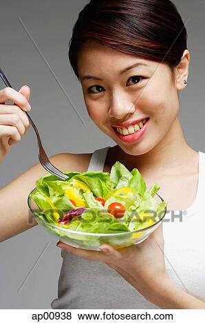 Stock Photo - Woman holding bowl of salad. Fotosearch