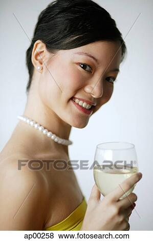 Woman holding wine glass, smiling at camera, portrait View Large Photo Image Stock Photo - Woman holding wine glass, smiling at camera, portrait. Fotosearch
