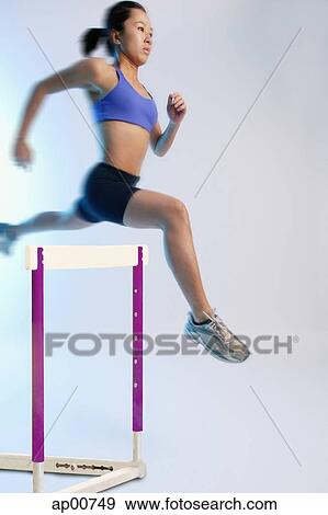 Woman jumping over hurdle View Large Photo Image Stock Photo - Woman jumping over hurdle. Fotosearch