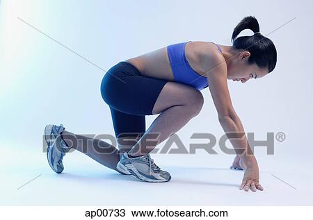 Woman kneeling at starting position, side view View Large Photo Image Stock Image - Woman kneeling at starting position, side view. Fotosearch